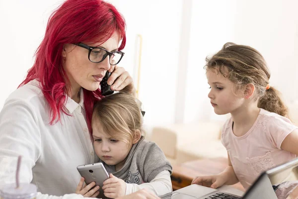 Lady with Laptop Talking on Phone While Kids Play with Smartphon