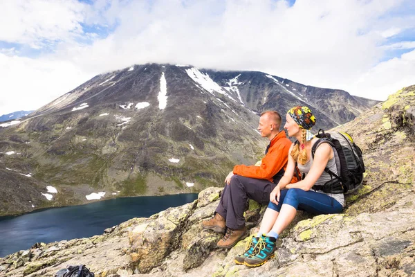 Sportpaar wandert auf Besseggen. Wanderer genießen schönen See und gutes Wetter in Norwegen. — Stockfoto