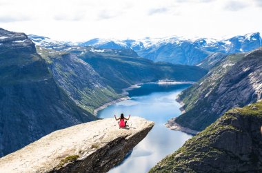 Mutlu insanlar uçurumun içinde Norveç gezisi sırasında sakin ol. Trolltunga yürüyüş yolu