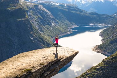 Mutlu insanlar uçurumun içinde Norveç gezisi sırasında sakin ol. Trolltunga yürüyüş yolu