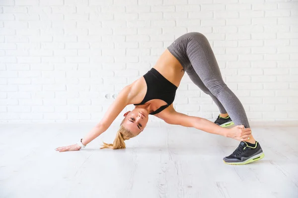 PhotoStudio içinde tuğla duvarın üzerinden poz spor kadın. Fitness motivasyon