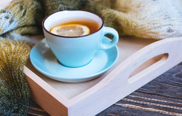 Tè caldo e tazza blu con limone su fondo legno - concetto di relax stagionale . — Foto Stock