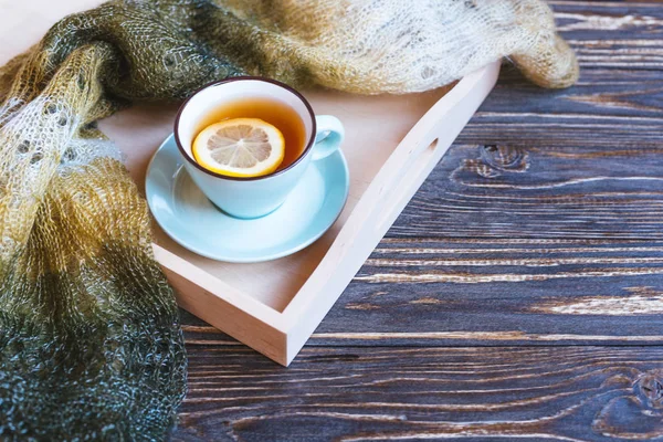 Heißer Tee und blaue Tasse mit Zitrone auf Holzhintergrund - saisonales Entspannungskonzept. — Stockfoto