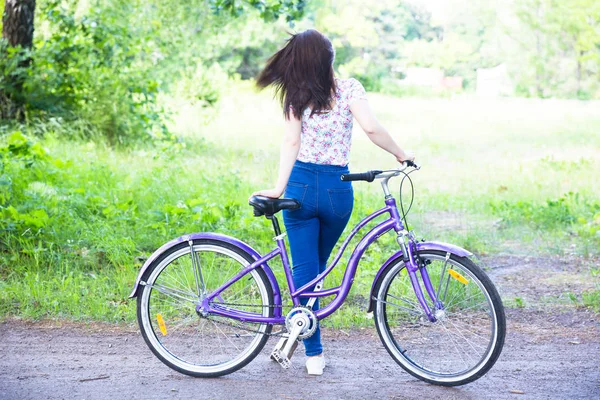 Happy pretty young girl bicycling on summer park. Happy relax time in city. Beautiful woman, sunny day — Stock Photo, Image