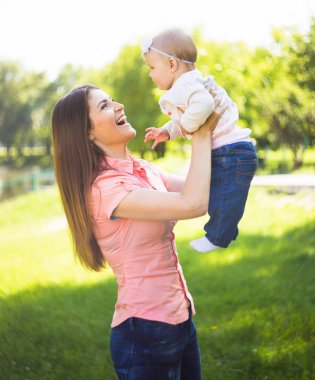 Şirin bebeği yaz güneşli Park açık ile oynarken Youmg mutlu kadın
