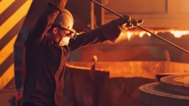 Genç adam çelik fabrikasında çalışıyor. Sıcak fabrikada çalışıyor.