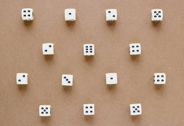 Gaming white dice pattern on brown background in flat lay style. Concept with copy space for games, game board, role playing game, risk, chance, good luck or gambling. Toned image top view. Close-up.