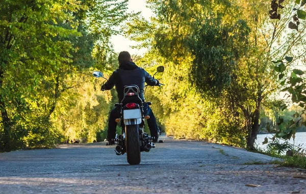 Motociclista montando sua moto em uma jaqueta preta de couro — Fotografia de Stock