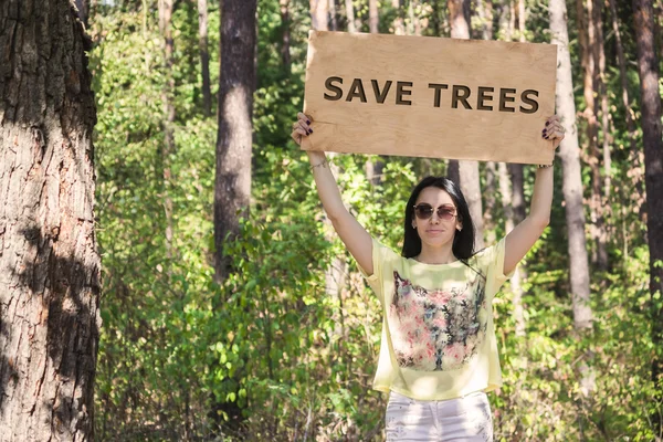 Femme dans la forêt tenant un panneau en bois avec les mots — Photo