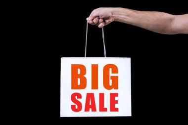 detay insan eli, izole siyah arka plan üzerine beyaz bir çanta ile alışveriş için basılı tutun. bir yazıt büyük satış