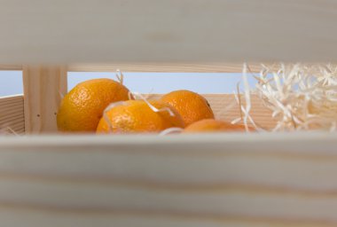 Ahşap kutusunda izole yapraklarla olgun lezzetli mandalina