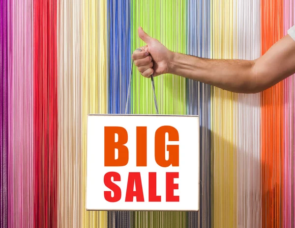detail of human hands, to hold,  shop, with a white bag, isolated on background colored blinds.   big sale sign