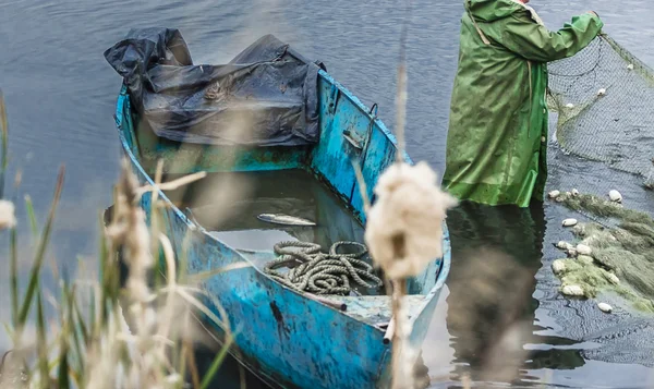 Fishing on the lake. Man pulls a fish net