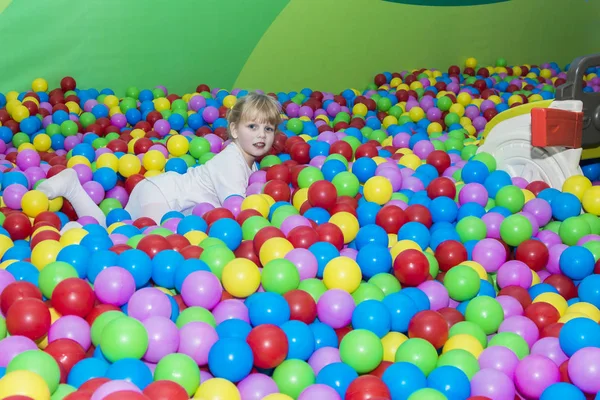 Niña sonriente jugando en el parque de bolas colorido parque — Foto de Stock