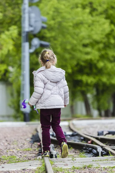 Een tiener meisje weg op spoor met bomen achter — Stockfoto