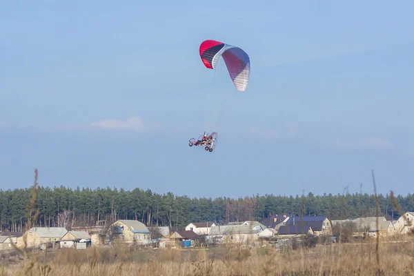 冒险男子活跃极限运动飞行员在空中飞行与副驾驶滑翔伞电机. — 图库照片