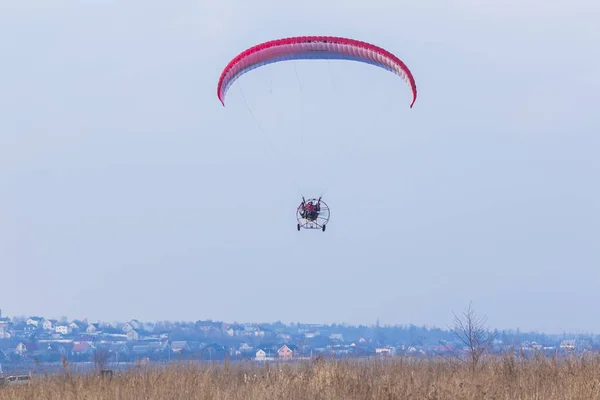 Adventure man active extreme sports pilot flying in the sky with paramotor paraglider paraglider motor.