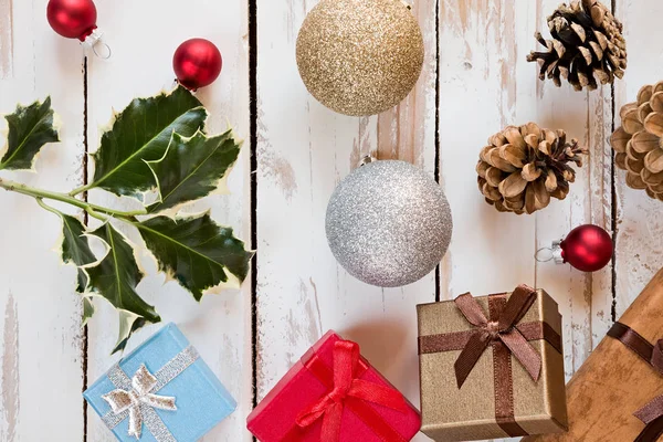 Closeup of Christmas presents and decorations over a rustic wood — Stock Photo, Image