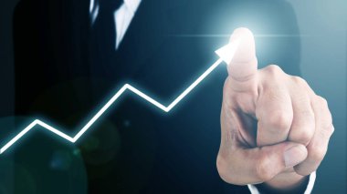 Man standing and pointing pen with Arrow and Line Visual Graphic on Light of Len flare and Bokeh blue background. COPY SPACE. Business Concept : Market Uptrend. Blue mood and tone.