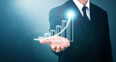 Man standing and shows outstretched hand with Bar Visual Graphic open palm on Light of Len flare and Bokh blue background. COPY SPACE. Market Uptrend.