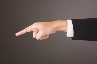 Close up of Asian Male Hand on gray Background in studio Taking With Studio Light. Pointing Action.