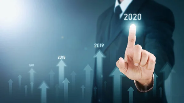 Man standing and pointing hand with Arrow and Line Visual Graphic on Light of Len flare and Boke blue background. COPY SPACE. Business Concept : Market Uptrend and Forecast 2020