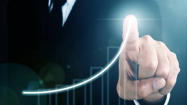 Man standing and pointing hand with Bar Chart and Line Visual Graphic on Light of Len flare and Bokeh blue background. COPY SPACE. Business Concept : Market Uptrend.