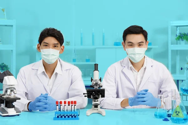 Двое Ученых Мужчин Носят Маску Лица Работая Лаборатории Глядя Камеру — стоковое фото