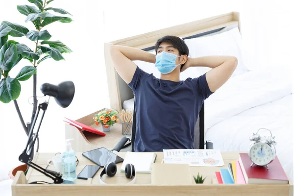 Cansado Asiático Homem Vestindo Máscara Usando Tablet Sentado Mesa Enquanto — Fotografia de Stock