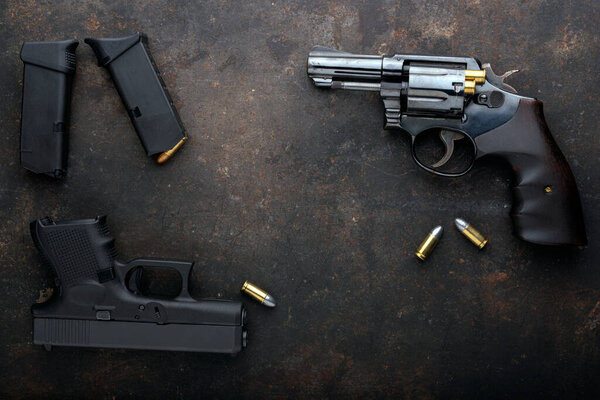 Gun with ammunition on iron dark background.