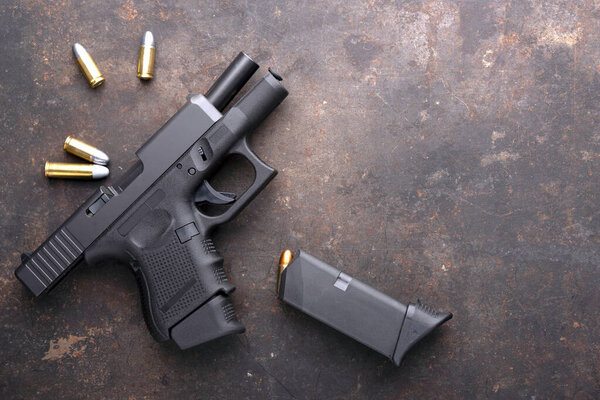 Gun with ammunition on iron dark background.