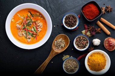 Beyaz fincanda kırmızı körili domuz ve arka planda Herb, Tayland adı PANG.