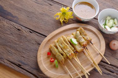 Pork satay - Fıstık soslu ızgara domuz eti ya da ekşi sos - ahşap masada Asya yemeği tarzı