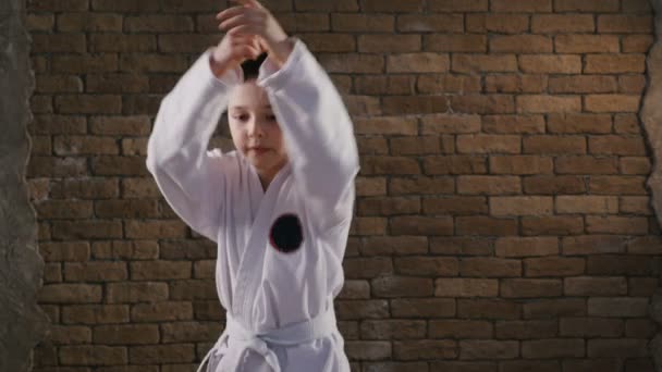 Sedmi letý sportovec postupy karate kata ve studiu — Stock video