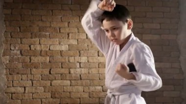Yarım bir profilde bir genç karateka standları ve kendini hareketleri savunma yok
