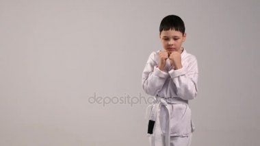 El grevler, beyaz bir kimono ve Studio bir beyaz kemer giymiş küçük bir karateka trenler