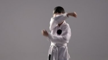 Bir çok genç karateka demostrates kendini savunma kata birkaç engelleme hareketleri ile.