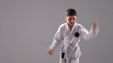 Yedi yaşında bir çocuk bir karate kata, çeşitli tutumları ve grev bir dizi gösterir