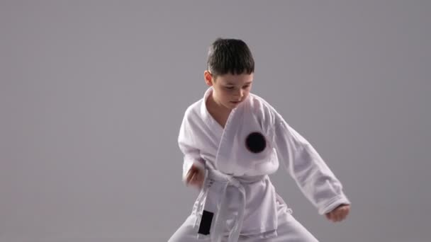 Un karateka muy joven demuestra un bloque de autodefensa y una huelga en el estudio — Vídeo de stock