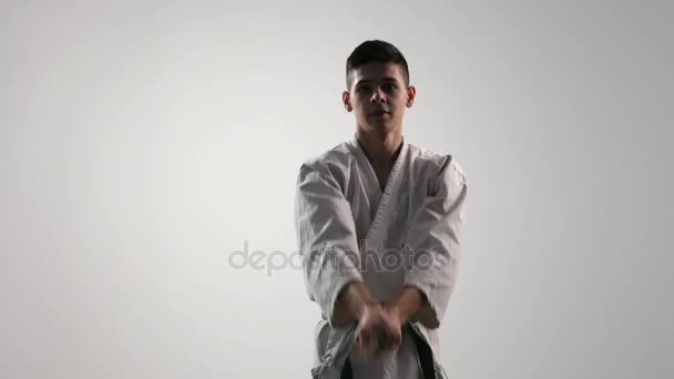 Las huelgas de katana hacia abajo son mostradas por un deportista de 18 años en el estudio — Vídeos de Stock