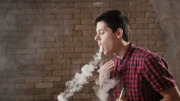 Un joven hace anillos de humo y cambia su dirección en slo-mo — Vídeo de stock