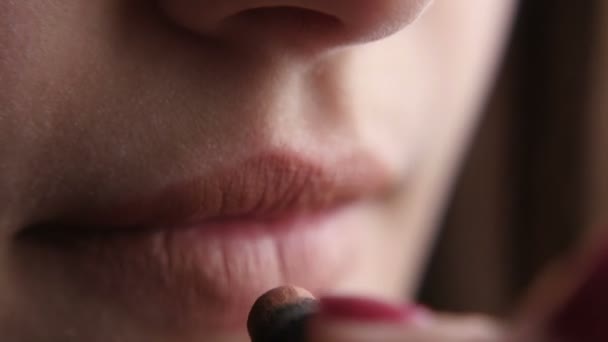 Jong meisje heeft betrekking op haar lippen met roze lippenstift, riekt, en toont rode manicure — Stockvideo