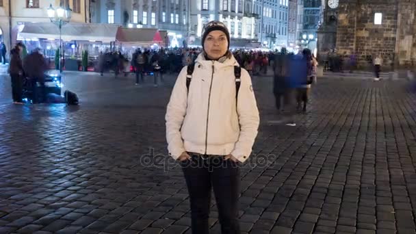 Female tourist is standing on Staromestske square in the evening, shot as a time lapse — Stock Video