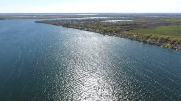 Blaues Wasser des Flusses Dnipro mit einem geschwungenen Flussufer, das grünlich bedeckt ist — Stockvideo