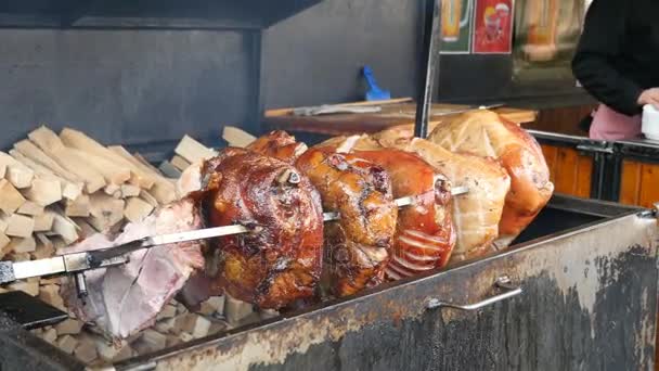 Rožnění velkých kloubů masa nad kovové pánev venku bar — Stock video