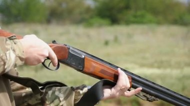 Adam bir tüfek kemer sırada, hedefler koyar ve kil target yavaş vuruyor