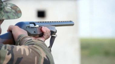 Silah, bir yerde--dan onun av tüfeği açık havada amaçlayan süre skeet Nikolaev, Ukrayna - 20 Mayıs 2017:Man trenler