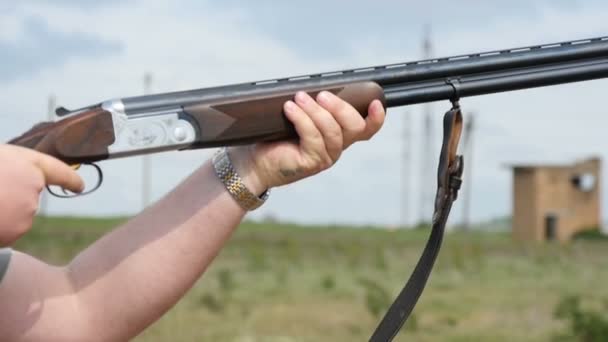 El hombre dispara desde una escopeta de doble cañón decorada al aire libre en cámara lenta — Vídeo de stock