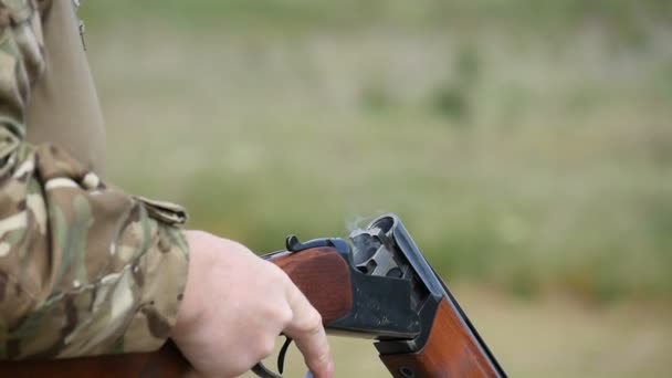 Člověk bere prázdnou kazetu a vložte novou kazetu do brokovnice v slo-mo — Stock video