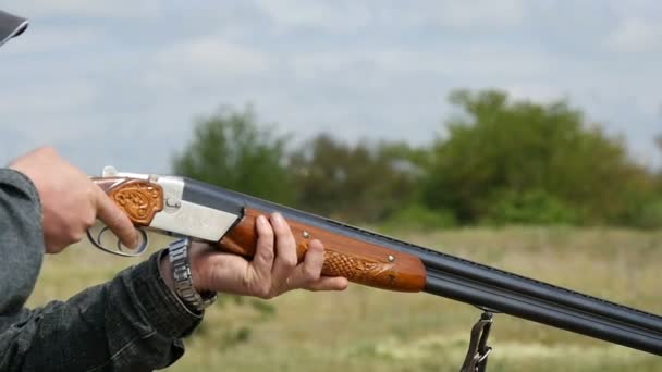 Николаев, Украина - 20 мая 2017 года: Какой-то человек целится и стреляет из двухствольной винтовки в поле в замедленной съемке — стоковое видео